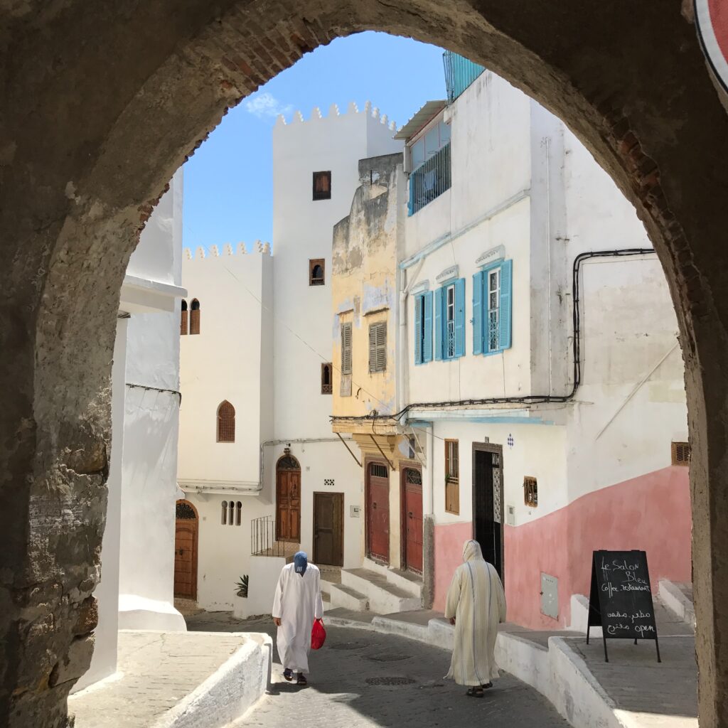 Mężczyźni ubtani tradycyjnie idą ulicą małego, marokańskiego miasta