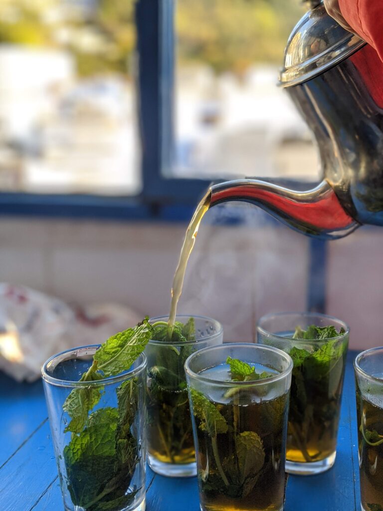 Czajnik z marokańską herbatą wlewaną do szklanek pełnych mięty