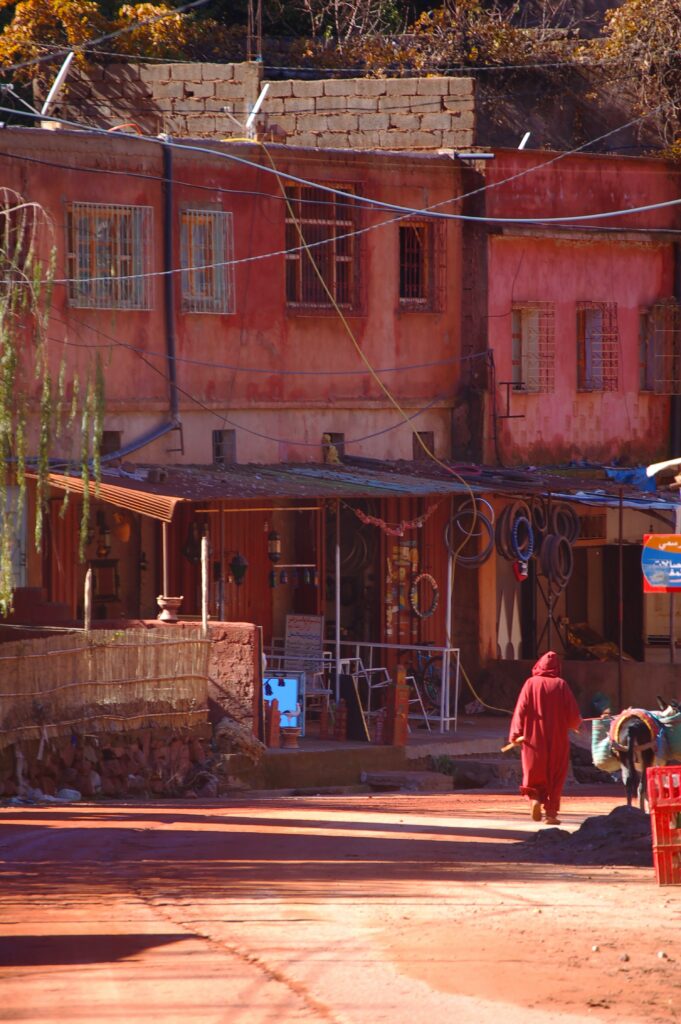 mężczyzna w jellabie idzie po drodze w marokańskiej wsi